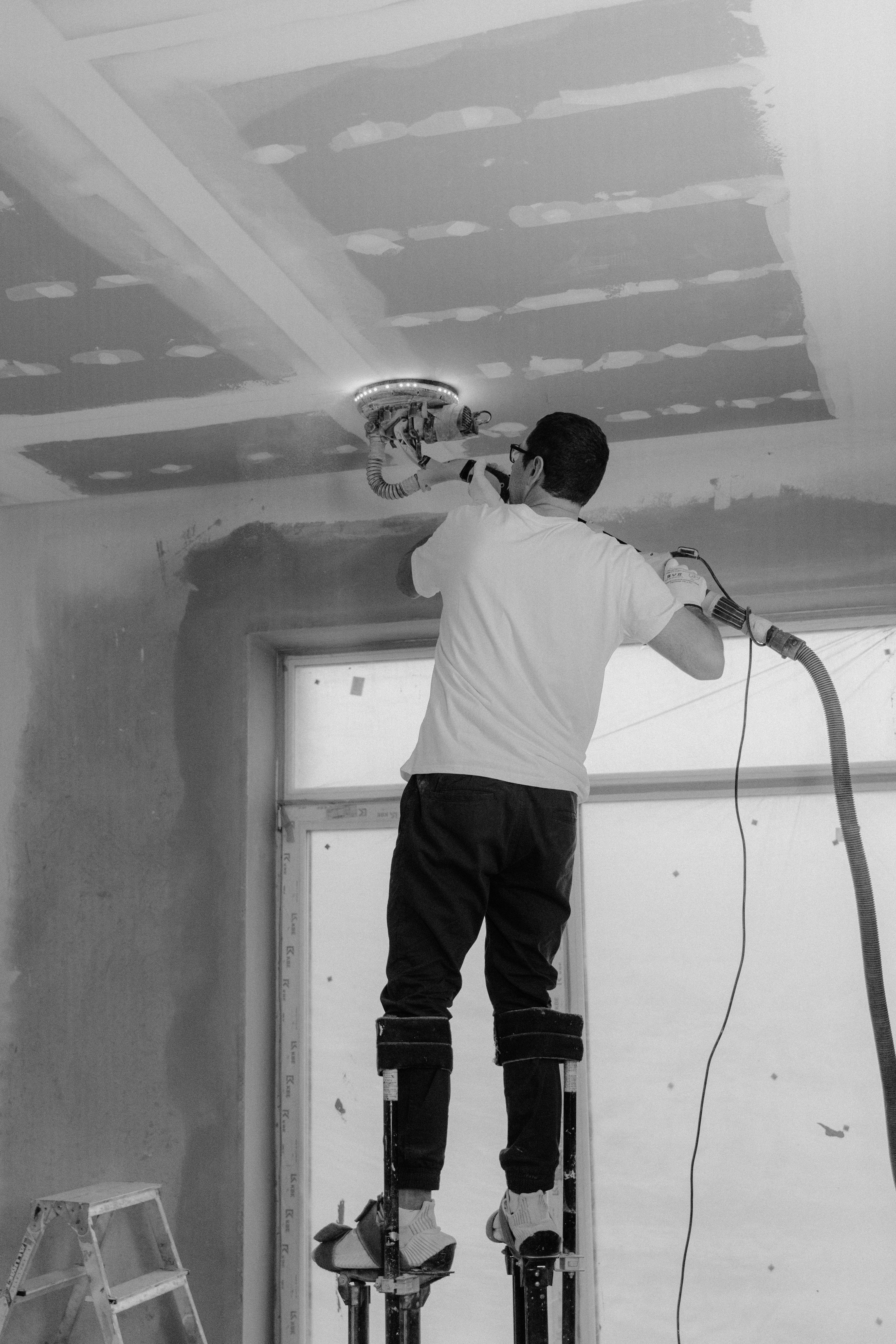 Drywall finisher working on a ceiling repair.